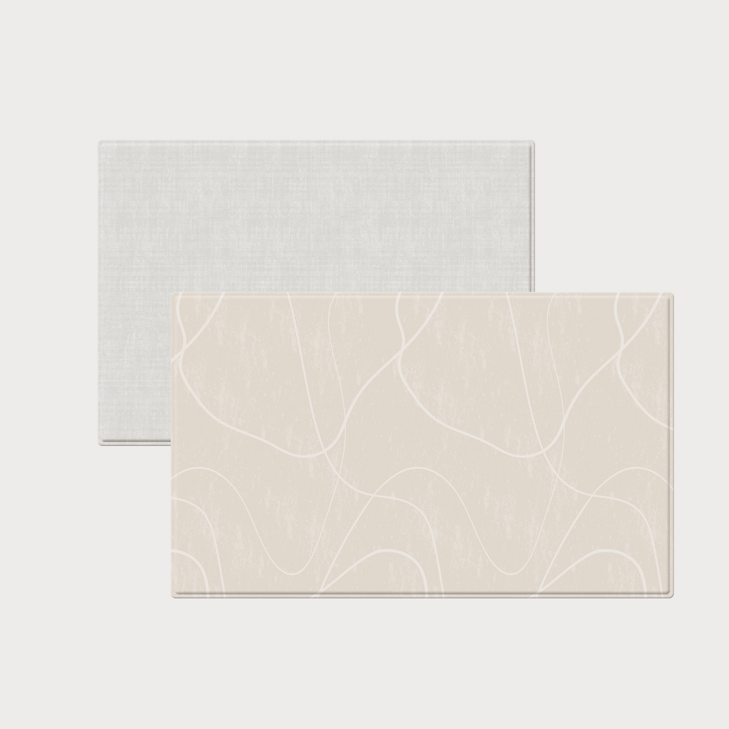 Översikt med två sidor av vändbar premiumlekmatta med mjuka bågar i varm sandbeige och vävd struktur i varmvitt.