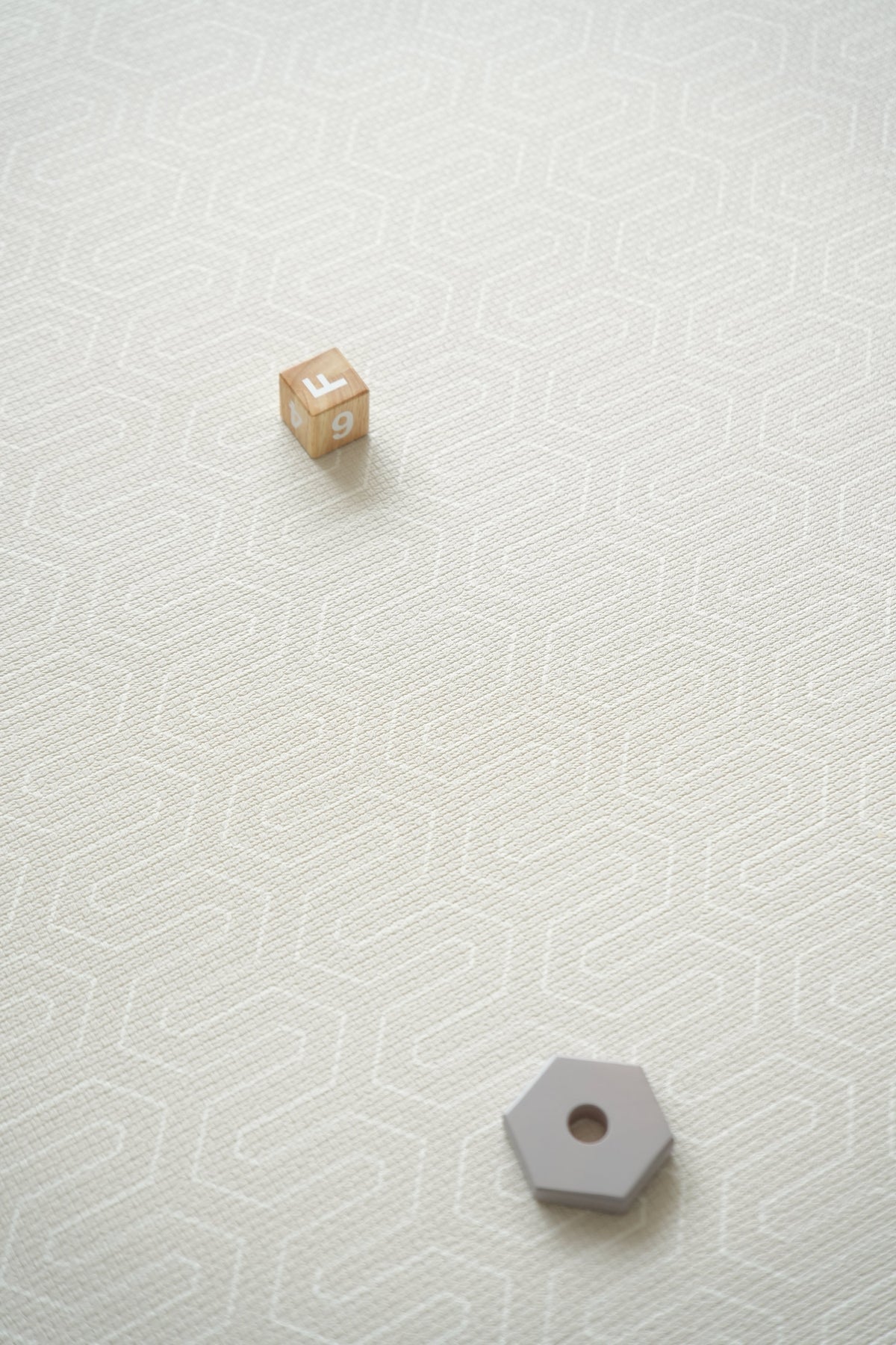 Vändbar premiumlekmatta i sandbeige geometriskt mönster.